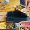 une femme entrain d'utilisé la Lunch Box Confort