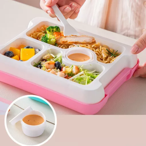 une personne qui mange dans la Boîte à Lunch Dino Bento